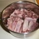 After cutting the rack of ribs into individual ribs or into quarters place the ribs into a pot.