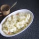 Starting to add cooled mashed potato to the fish pie