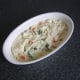 Fish pie filling is carefully smoothed out in the base of the baking dish
