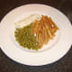 Ling, fries and peas are plated