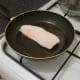 Ling is added to frying pan on skin side