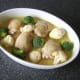 Broccoli and cauliflower florets are interspersed between the chicken thighs