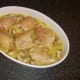 Chicken thighs are folded over and laid skin sides up in rice and stock