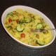A fork is used to carefully turn the garnishings through the casserole