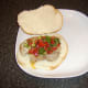 Salsa is spooned on to pork leg steak