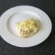 Grated cheese is laid on top of the steak on the roll