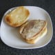 Rested leg of pork steak is laid on bread roll