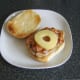 Pineapple ring is laid on bacon and pork steak