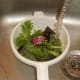 Salad leaves are washed under running water