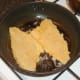 Breaded sea bream fillets are added to frying pan