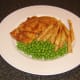 Garden peas are served with the sea bream fillets and chips