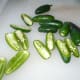 Wear gloves and slice the jalapeno peppers in half. Then remove most of the seeds. I leave some seeds in because I love the heat.