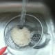 Rice is washed through a sieve