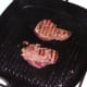 Kangaroo steaks are turned in griddle pan