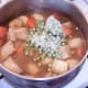 Frozen peas are added to kangaroo and vegetable stew