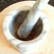 Grinding cumin seeds with lestle and mortar