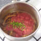 Tomatoes and chopped chilli are added to spiced onions and garlic