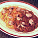 Fried frogs' legs are laid on sauce and rice