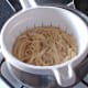 Spaghetti is drained through a colander