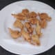 Battered frogs' legs are drained on kitchen paper
