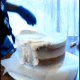 Start smoothing around the sides and top, giving an even layer all the way around the entire cake.