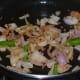 Step three: Add slit green chilies and continue sauteing.