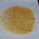 Step ten: Place the ball on a greased plastic sheet. Keep the ball in the center. Flatten it. Apply some oil on the top. Place another greased transparent plastic on it. Roll the patty with the help of a rolling pin to get a round flatbread.