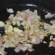 Step three: Add onions and garlic. Stir-fry until they turn transparent and pinkish.