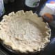 The pie crust, once worked onto the pie dough, but before it is cooked or has aluminum foil over it.