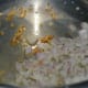 Step two: Heat oil in a pressure cooker base or skillet. Add minced garlic. Saute till they turn golden. Add chopped onions. Saute till they are transparent.
