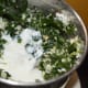 Step five: Grind, gradually adding yogurt/curd/buttermilk to get a smooth liquid. Pour it into a bowl. Add remaining yogurt/curd. Mix well. Add water to adjust the consistency.