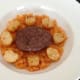 Burger and potatoes are arranged on carrot bed