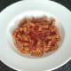 Pasta is plated to form a bed for the burger