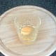 Egg is broken in to small glass or cup for adding to poaching water