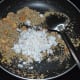 Step four: Add grated coconut. Mix well. Set aside for cooling.