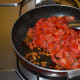 Step five: Throw in the chopped tomatoes. Increase the heat.