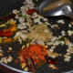 Step four: Throw in the turmeric powder, red chili powder, and coriander powder.