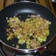 Heat oil in a deep-bottomed pan or wok. Throw in the mustard seeds and let them crackle. Add white lentils and sauté for 30 seconds. Throw in the grated ginger, chopped onions, and turmeric powder.