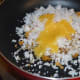 Step four: Heat the same pan. Add powdered jaggery. Sprinkle a few drops of water. Jaggery melts. Turn off the heat. Add grated coconut and ghee.