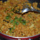 Step eight: Add half of the chopped coriander leaves. Mix well. Turn off the heat. Transfer the curry to a serving bowl.