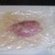 Seasoned chicken breast encased in plastic wrap