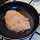 Starting to fry chicken schnitzel