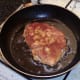 Chicken schnitzel is turned to fry on second side