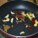 Step one: Heat ghee or butter in a pan. Add cumin seeds. Let them sizzle. Throw in ginger, dry red chili, and garlic.
