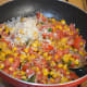 Step six: Add grated cheese. Stir the mix.