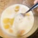 Crack eggs into a mixing bowl. Add a splash of milk and stir.