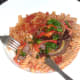 Enjoying ostrich burger and sauteed kale on spicy pasta