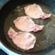 Bacon is turned in frying pan