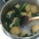 Potatoes and kale are carefully turned in flavoured butter