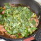 Kale is added to sauteed bacon and onion